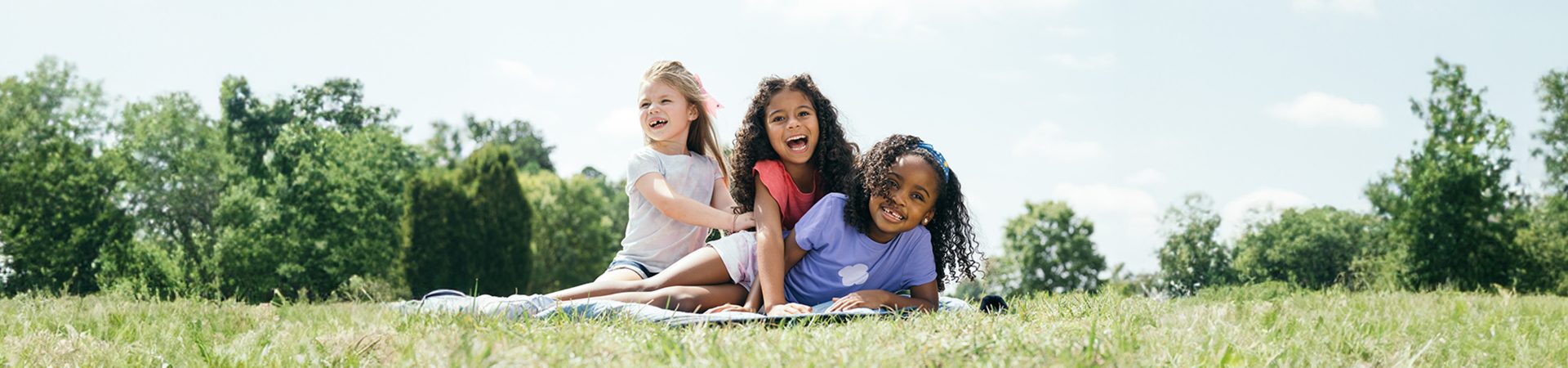 Three young Girl Scouts playing in the grass 