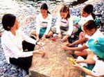 Photo of Junior Girl Scouts and leader making origami. &copy; GSUSA. All rights reserved. (Photographer: Lori Adamski-Peek)