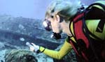 Photo of girl diving underwater using flashlight. (Ivy Kelley, Florida Keys National Marine Sanctuary)