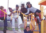 Photo of Girl Scouts on monkeybars of a playground.