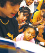 Photo of a volunteer reading to children. &copy; GSUSA. All rights reserved.