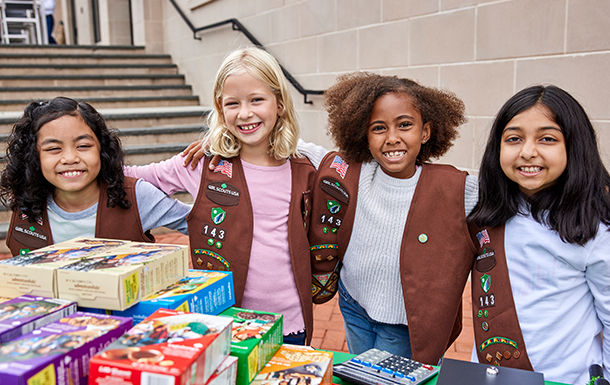 Cuatro Girl Scout Brownies abrazadas