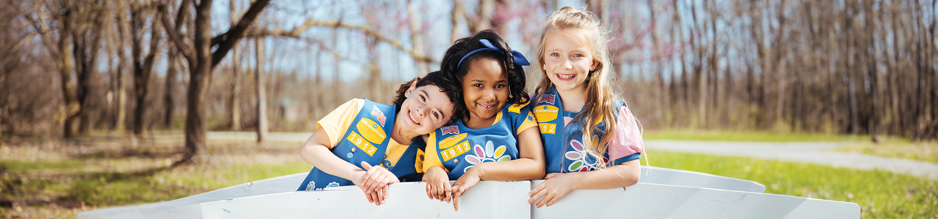  Group of Girl Scouts smiling at each other outdoors 